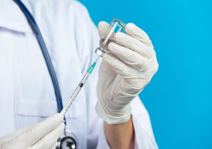 close up picture of docter's  hands holding hypodermic syringe