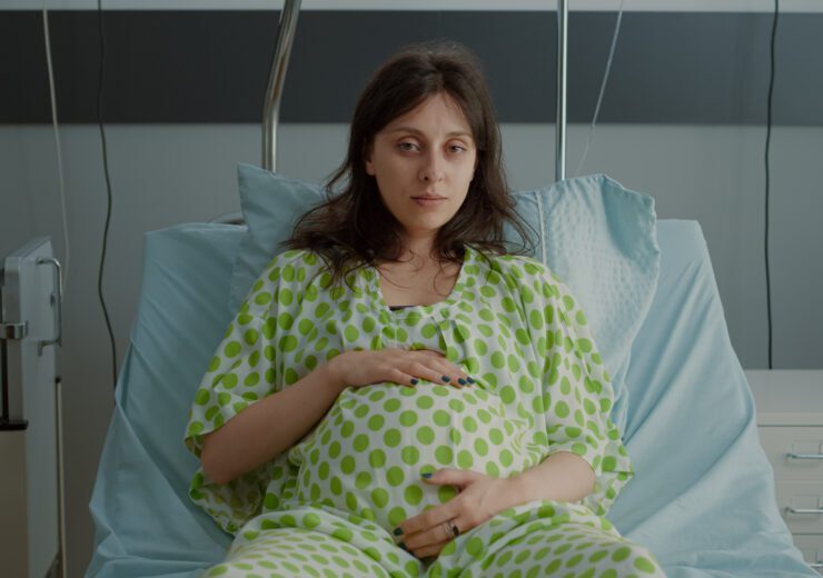 Portrait of pregnant woman laying in hospital ward bed